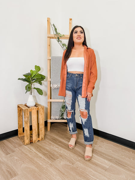 woman wearing beige heels with jeans and an orange open top